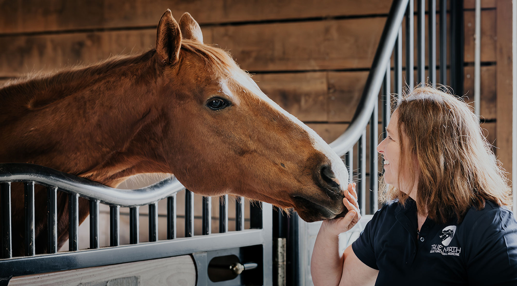 close up image of True North owner petting a horse